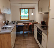 Moderne Küche mit Essbereich, viel Licht und Blick auf den Garten in Mühlbach am Hochkönig.