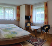 Gemütliche Ferienwohnung mit Doppelbett, Sitzecke und Blick ins Freie. Ideal für einen erholsamen Urlaub.
